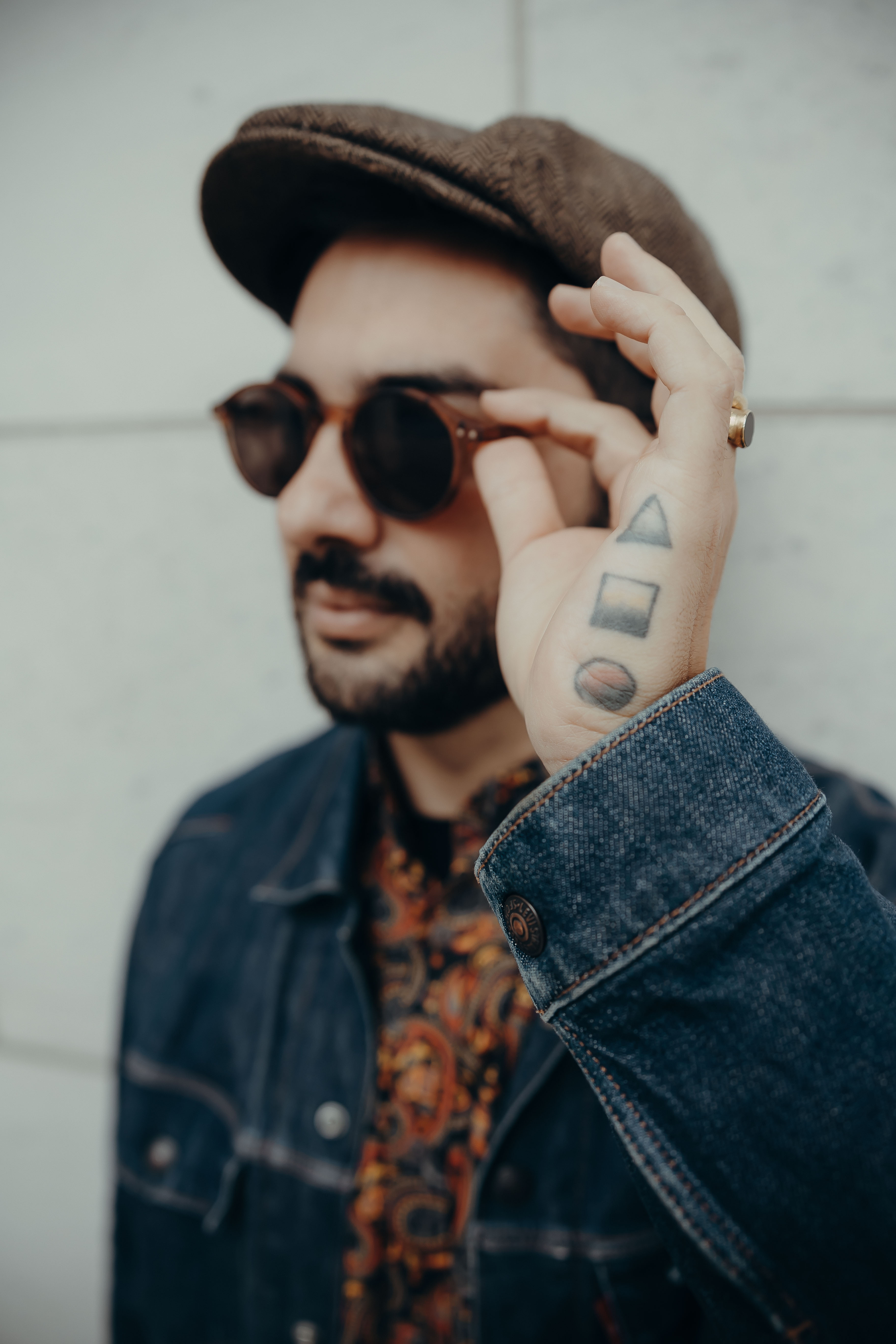 Juano San, hat and sunglasses, hand tattoo detail