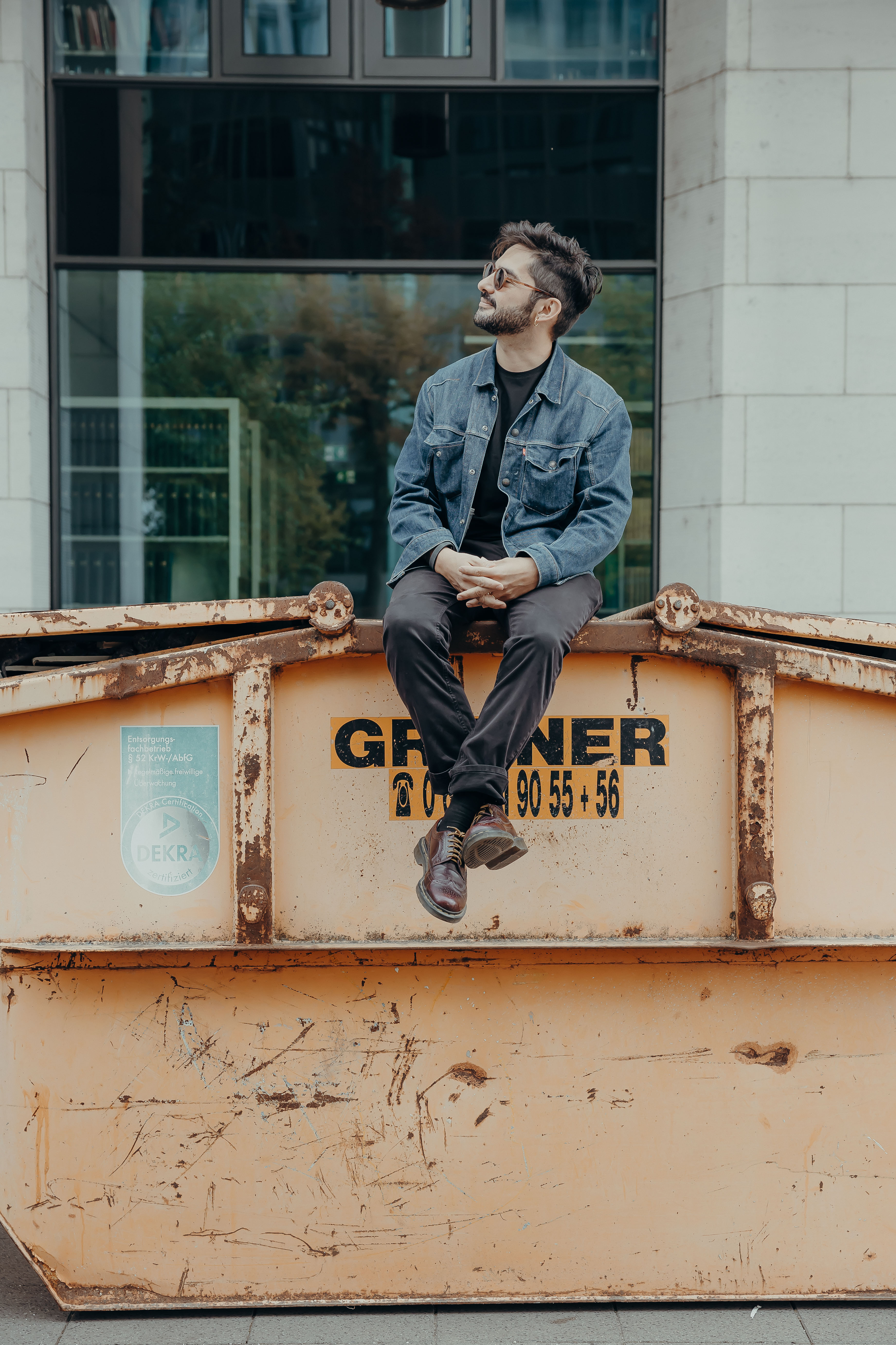 Juano San, laughing, sitting on a construction container
